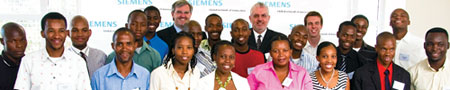 Trainees of the Siemens Apprenticeship Training programme accompanied by (in the background) Siemens chief executive Sigi Proebstl (left) and Harry Hollier, Siemens executive director (right)